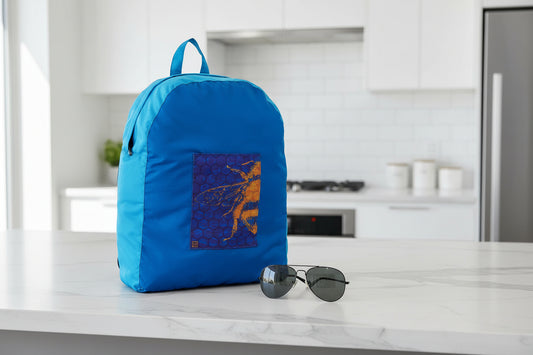 Bee Hive variant ONYA 100% recycled plastic backpack on a kitchen benchtop next to sunglasses