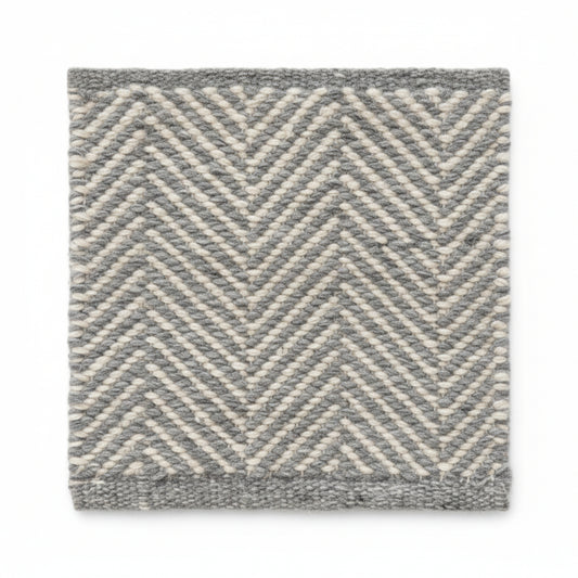 Close-up texture detail of the sustainable herringbone weave pattern on a Henshall grey recycled plastic floor mat.