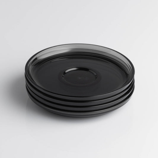 Pack of 4 HuskeeRenew translucent reusable small 3oz espresso saucers featuring the signature vertical ribbed design made from high-performance recycled polymer top view in smoke.