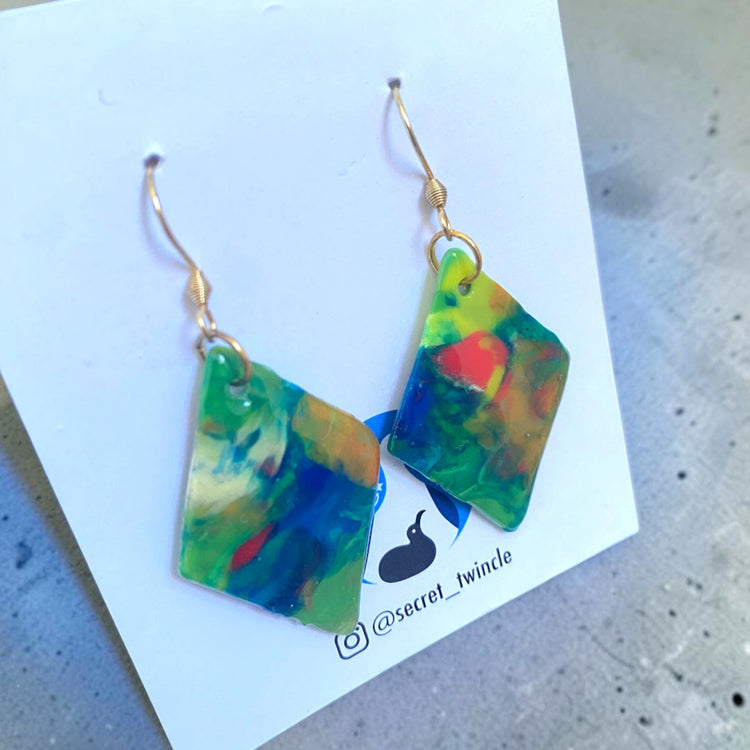Flat lay photo of the geometric green blue diamond-shaped upcycled earrings, presenting an ideal gift for sustainable fashion collections.