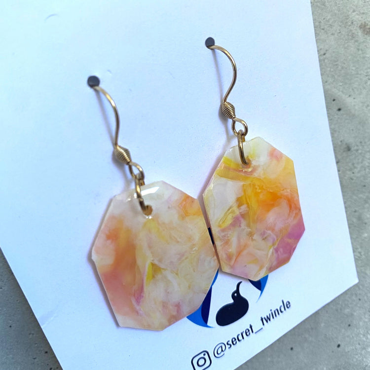 Flat lay studio shot of the pastel pink and white geometric octagon upcycled earrings, presenting an ideal gift for eco-conscious fashion lovers.