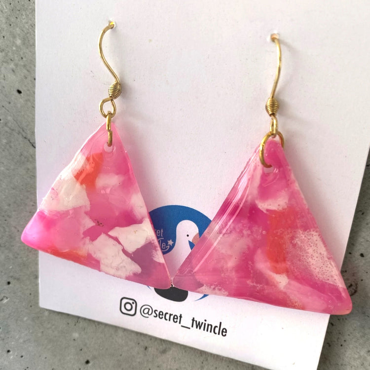 Flat lay presentation of the geometric pink and white triangle-shaped upcycled dangles, offering a perfect sustainable jewelry gift option.