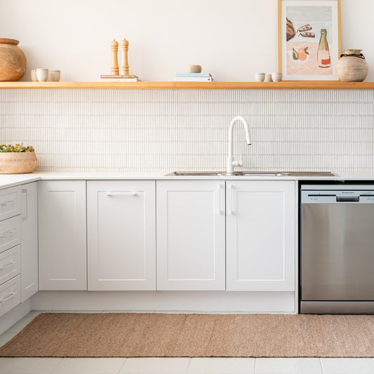 Zebra Home Fraser warm beige machine-washable runner mat placed along a bright, moder kitchen floor layout.