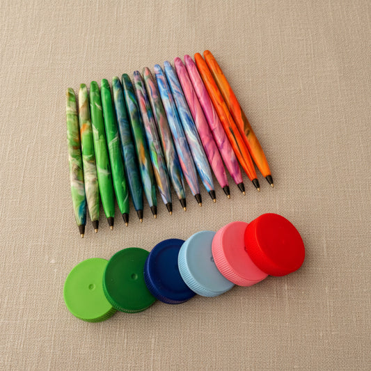 Colourful recycled plastic refilable pens with examples of the lids they have been made from