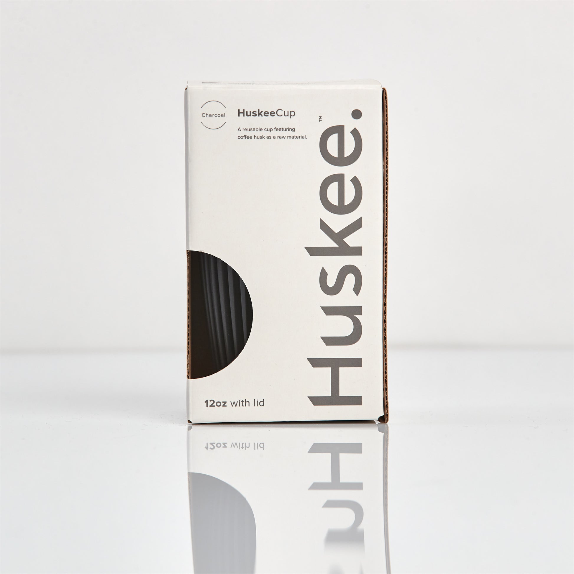 Large 12oz HuskeeOriginal reusable coffee cup featuring the signature vertical ribbed design made from sustainable coffee husk waste in charcoal in box.