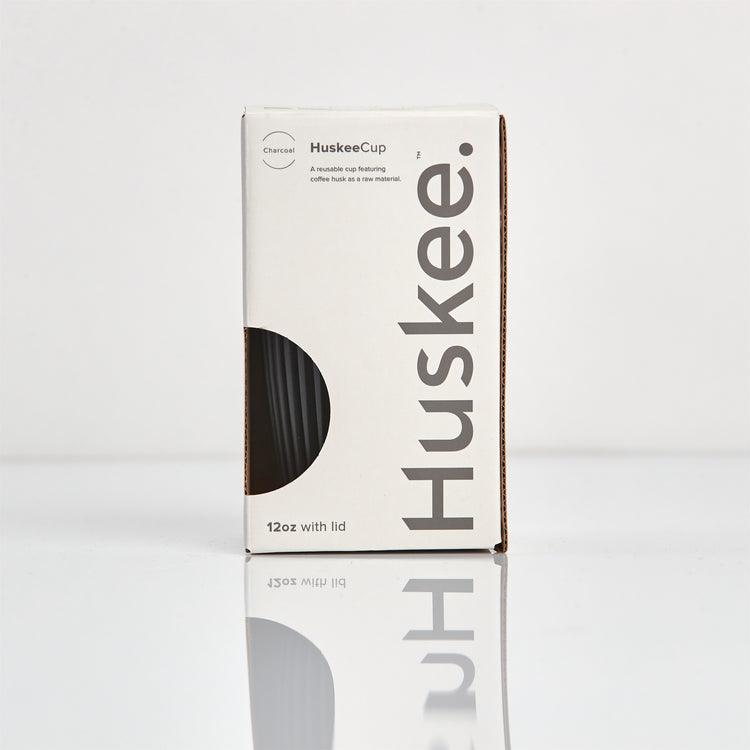 Large 12oz HuskeeOriginal reusable coffee cup featuring the signature vertical ribbed design made from sustainable coffee husk waste in charcoal in box.