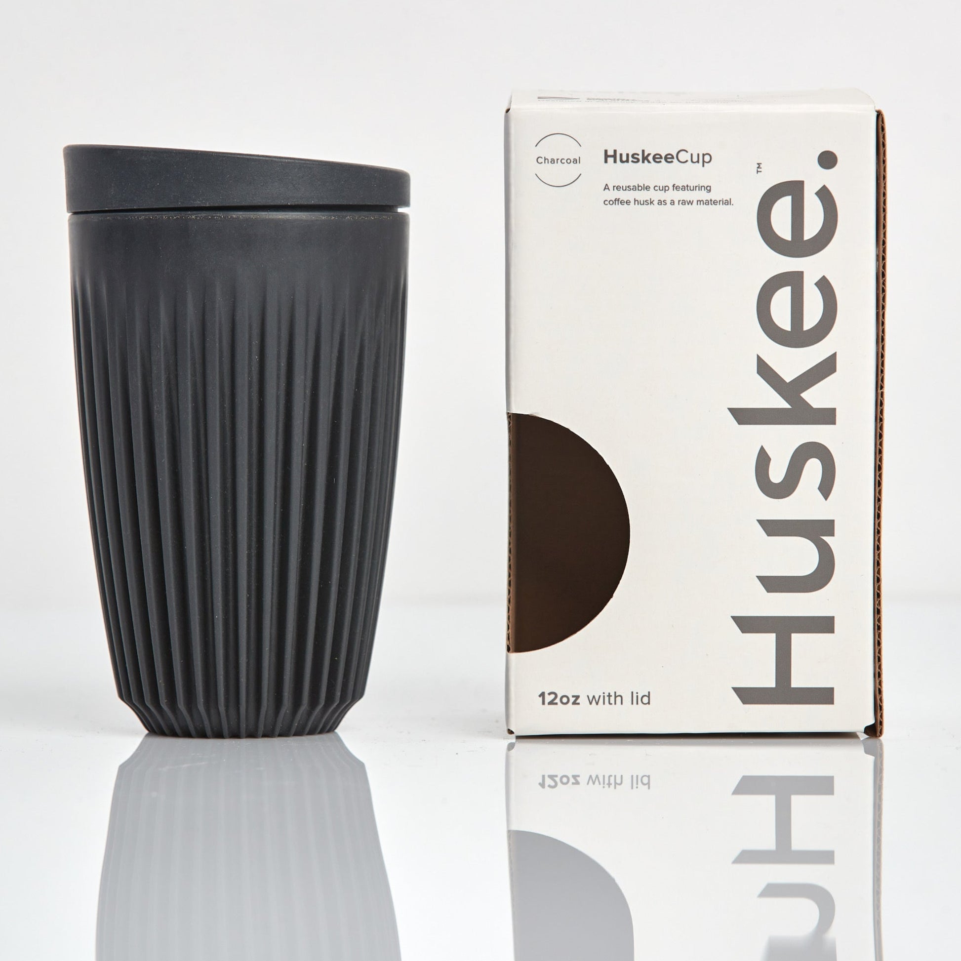 Large 12oz HuskeeOriginal reusable coffee cup featuring the signature vertical ribbed design made from sustainable coffee husk waste in charcoal with box.