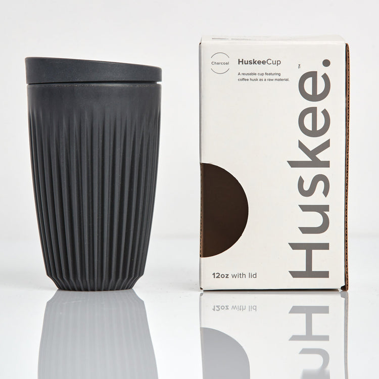 Large 12oz HuskeeOriginal reusable coffee cup featuring the signature vertical ribbed design made from sustainable coffee husk waste in charcoal with box.