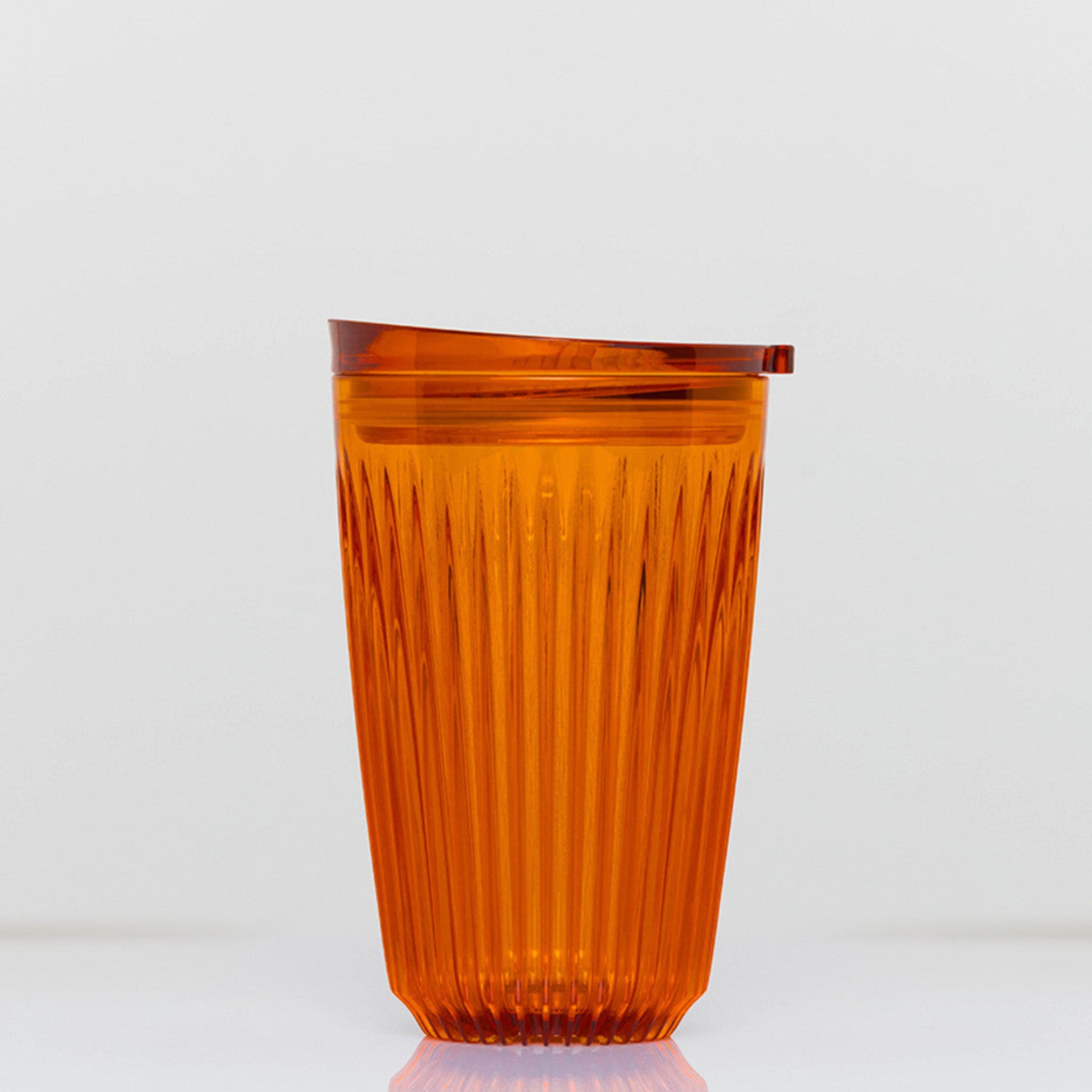 Large 12oz HuskeeRenew translucent reusable coffee cup featuring the signature vertical ribbed design made from high-performance recycled polymer in amber.