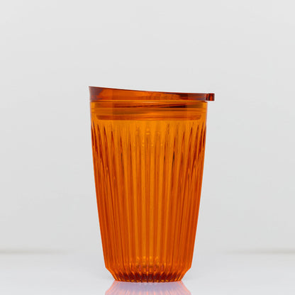 Large 12oz HuskeeRenew translucent reusable coffee cup featuring the signature vertical ribbed design made from high-performance recycled polymer in amber.