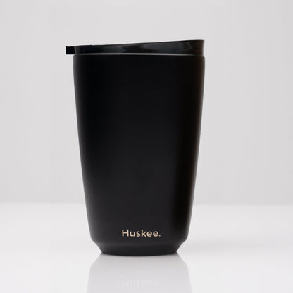Large 12oz HuskeeSteel reusable coffee cup with matching stopper lid made from 91% recycled vacuum insulated stainless steel in black.