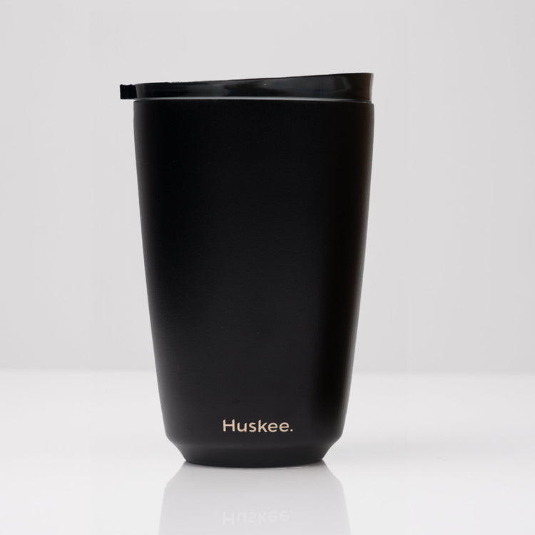 Large 12oz HuskeeSteel reusable coffee cup with matching stopper lid made from 91% recycled vacuum insulated stainless steel in black.