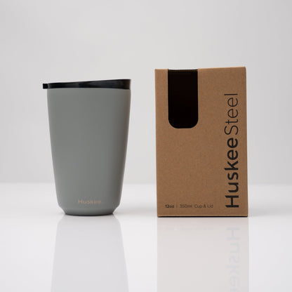 Large 12oz HuskeeSteel reusable coffee cup with matching stopper lid made from 91% recycled vacuum insulated stainless steel in slate with box.