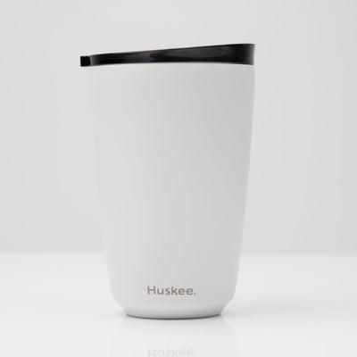Large 12oz HuskeeSteel reusable coffee cup with matching stopper lid made from 91% recycled vacuum insulated stainless steel in white.