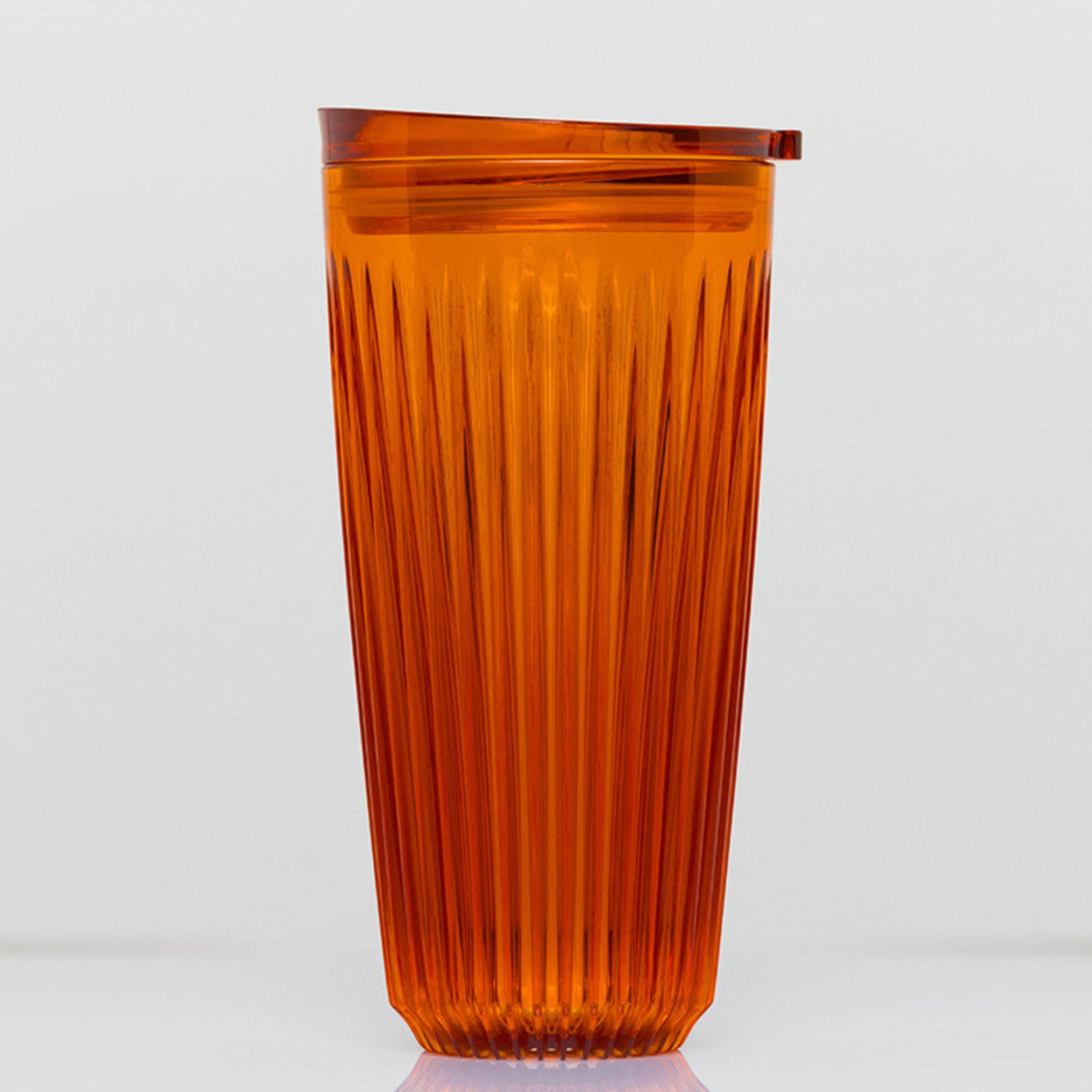 Extra large 16oz HuskeeRenew translucent reusable coffee cup featuring the signature vertical ribbed design made from high-performance recycled polymer in amber.