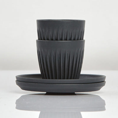 Set of 2 small 3oz HuskeeOriginal reusable espresso cups with saucers featuring the signature vertical ribbed design made from organic coffee husk waste in charcoal.