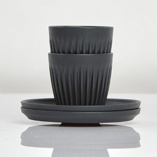 Set of 2 small 3oz HuskeeOriginal reusable espresso cups with saucers featuring the signature vertical ribbed design made from organic coffee husk waste in charcoal.