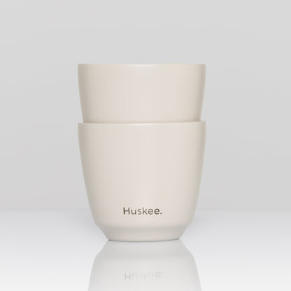 Set of 2 HuskeeSteel 3oz espresso cups crafted from 91% recycled double-wall vacuum insulated stainless steel in white.