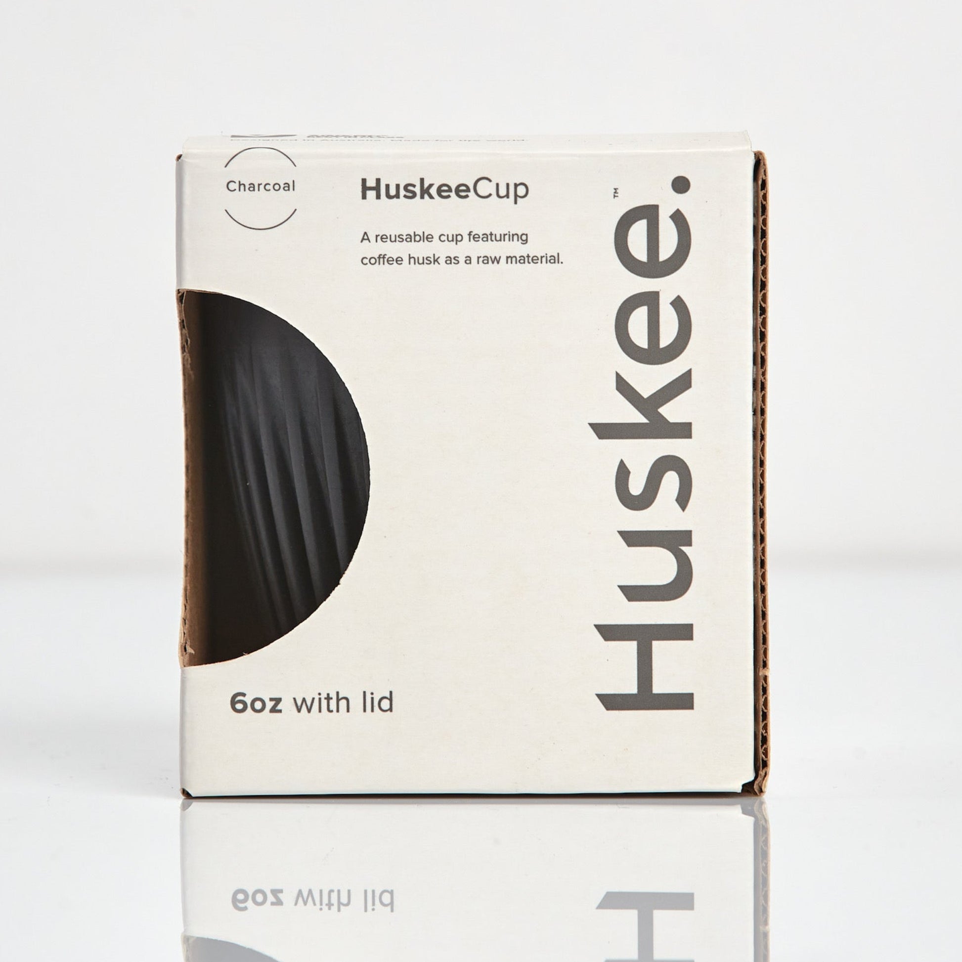 A 6oz HuskeeOriginal reusable coffee cup featuring signature ribbed design made from coffee husk waste charcoal in box.