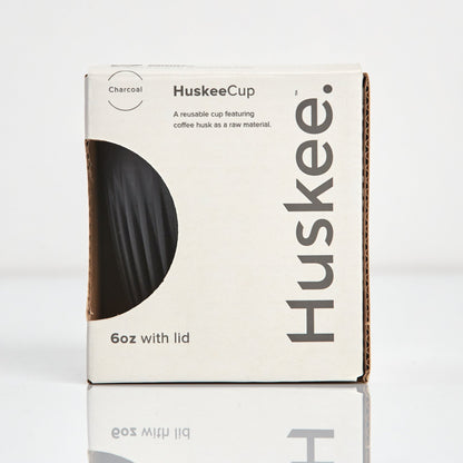 A 6oz HuskeeOriginal reusable coffee cup featuring signature ribbed design made from coffee husk waste charcoal in box.