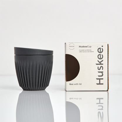 A 6oz HuskeeOriginal reusable coffee cup featuring signature ribbed design made from coffee husk waste charcoal with box.