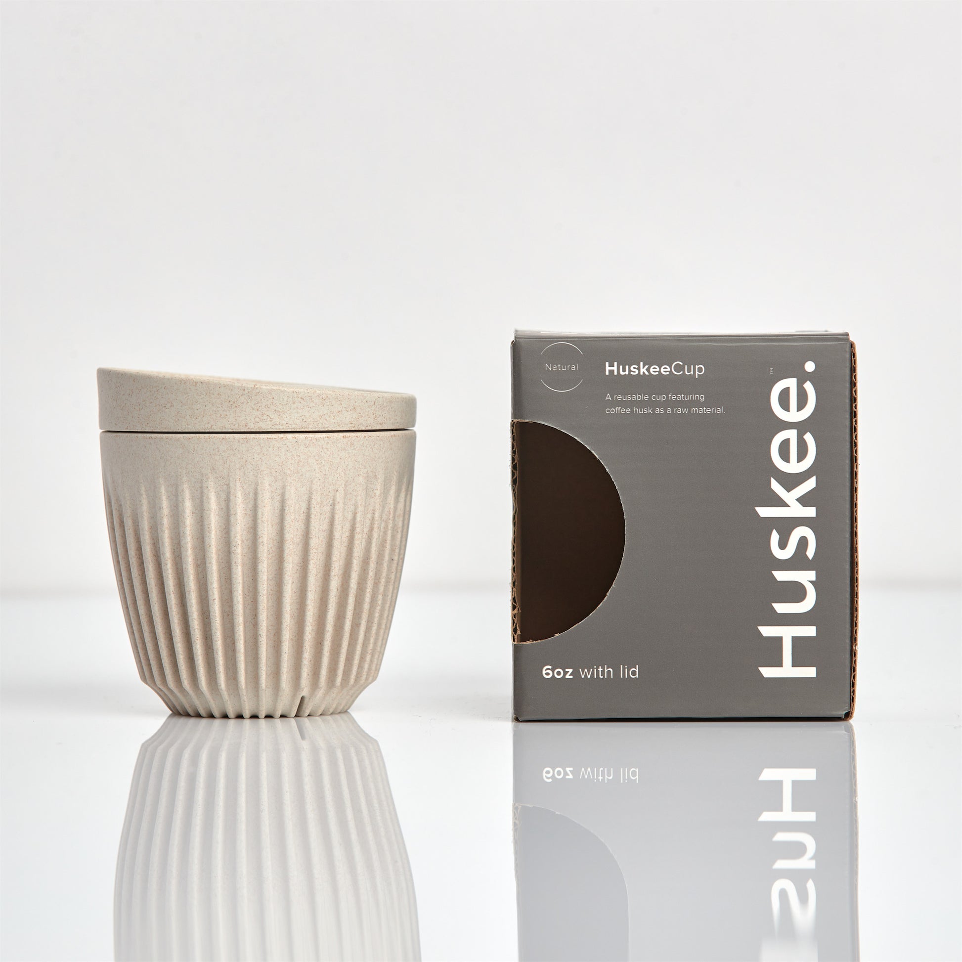 A 6oz HuskeeOriginal reusable coffee cup featuring signature ribbed design made from coffee husk waste natural with box.