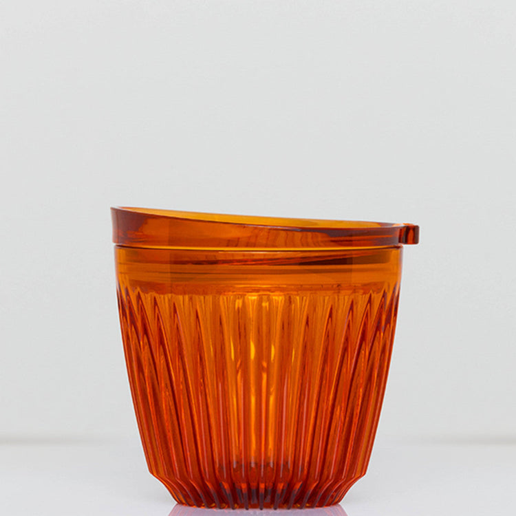 A small 6oz HuskeeRenew translucent reusable coffee cup made from high-performance recycled polymer in amber.