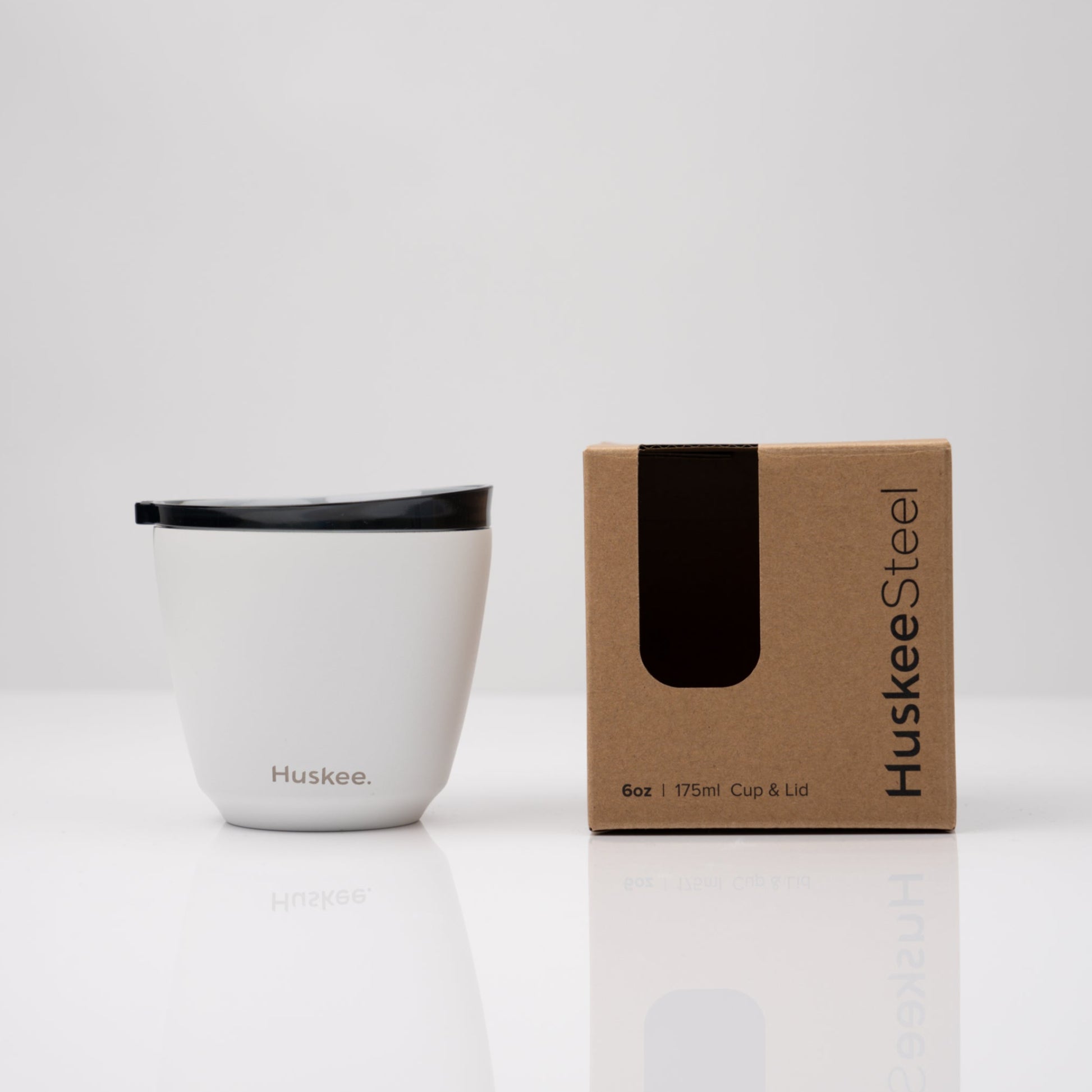 Small 6oz HuskeeSteel reusable coffee cup with matching stopper lid made from 91% recycled stainless steel in white with box.