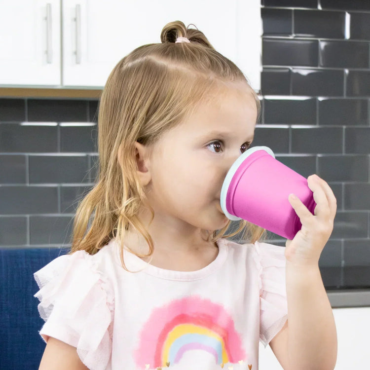 Re-Play recycled plastic 6oz tiny tumbler childs drinking mug with lid being used by a child learning to drink independently.