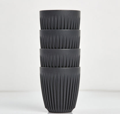 Standard 8oz HuskeeOriginal reusable coffee cup featuring the signature vertical ribbed design made from sustainable coffee husk waste in charcoal 4 pack.