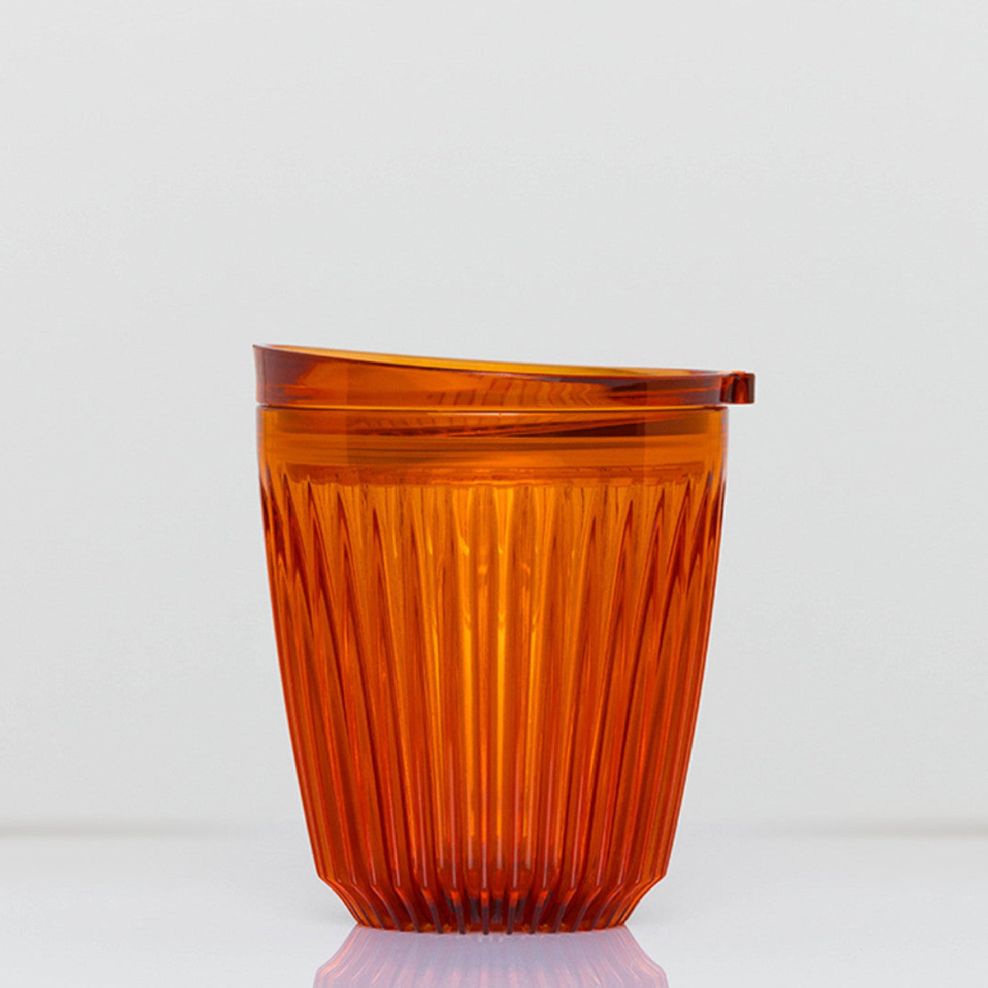 Standard 8oz HuskeeRenew translucent reusable coffee cup featuring the signature vertical ribbed design made from high-performance recycled polymer in amber.