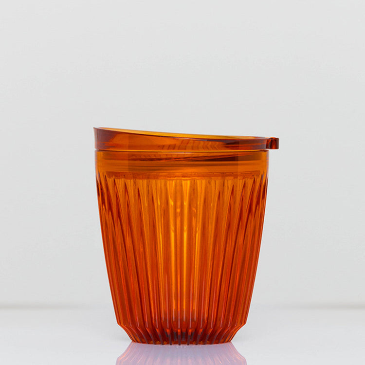 Standard 8oz HuskeeRenew translucent reusable coffee cup featuring the signature vertical ribbed design made from high-performance recycled polymer in amber.