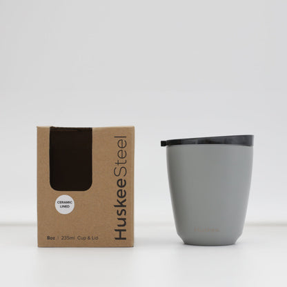 Standard 8oz HuskeeSteel reusable coffee cup with matching stopper lid made from 91% recycled vacuum insulated stainless steel in slate with box.