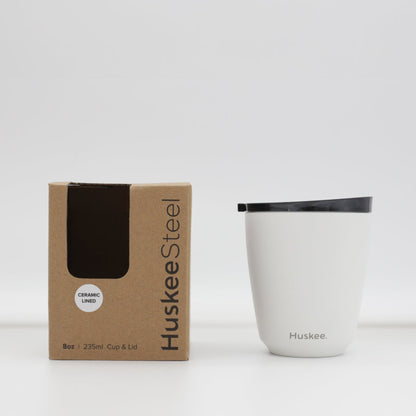 Standard 8oz HuskeeSteel reusable coffee cup with matching stopper lid made from 91% recycled vacuum insulated stainless steel in white with box.