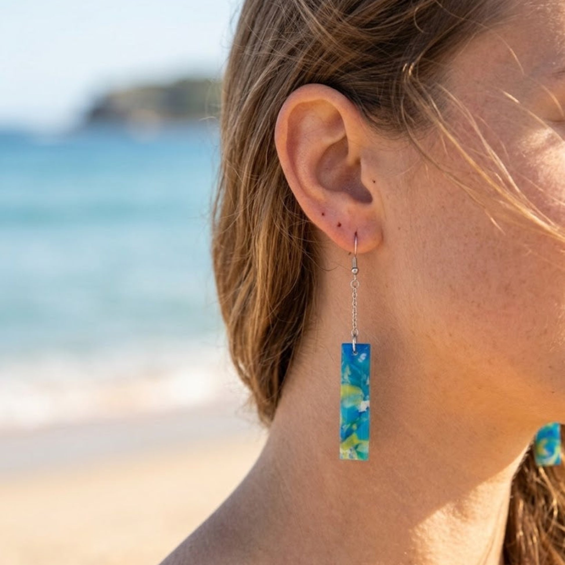 On-model style photo showcasing the fit, movement, and drop length of the upcycled blue and green rectangular chain link earrings in Australia.