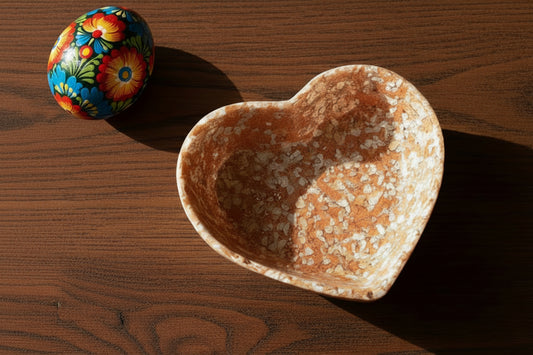 Heart-shaped bowl made from eggshell and bio-resin on a wooden table top with a hand painted egg