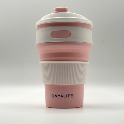 Collapsible 350ml silicone coffee cup with secure lid and heat-protective sleeve, shown expanded and collapsed with its reusable storage pouch. Shown in Blush Pink