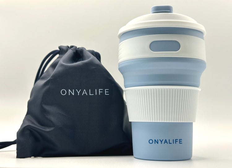 Collapsible 350ml silicone coffee cup with secure lid and heat-protective sleeve, shown expanded and collapsed with its reusable storage pouch. Shown in Powder Blue with pouch