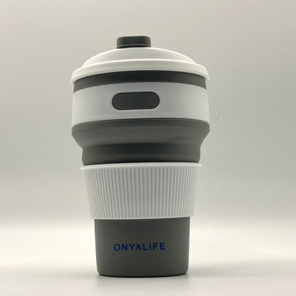 Collapsible 350ml silicone coffee cup with secure lid and heat-protective sleeve, shown expanded and collapsed with its reusable storage pouch. Shown in Slate Grey