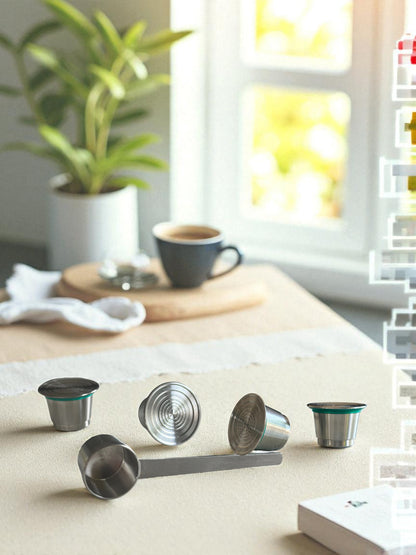 Four Pod Star Nesspresso Original reusable stainless steel coffee pods on a kitchen bench with a scoop and cup of coffee in the background
