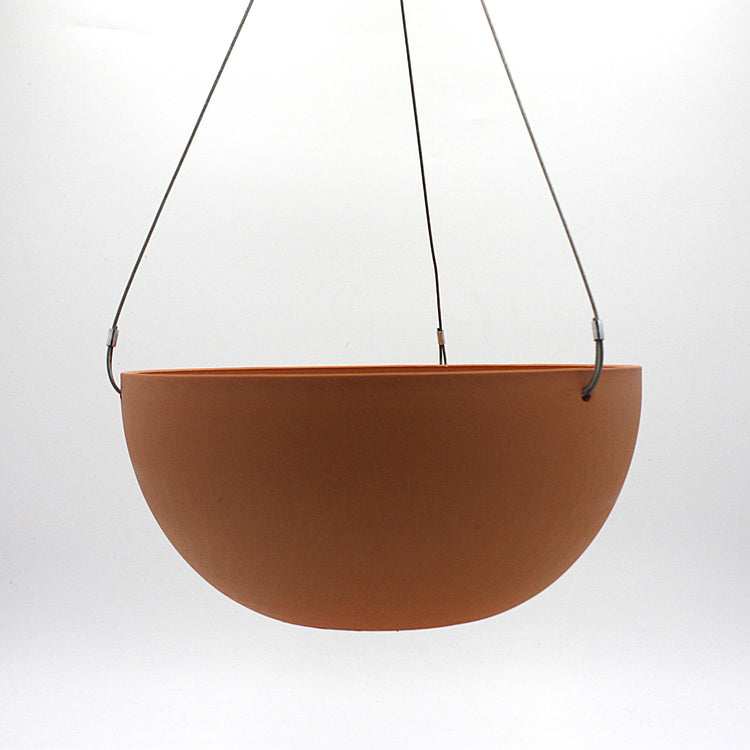 A hanging planter suspended by marine wire against a plain white background. Made from recycled plastic. Shown in Dusted Clay