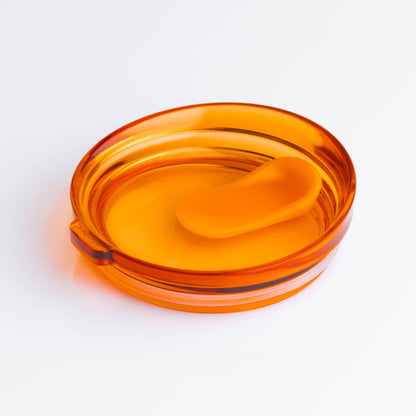 A universal 6oz HuskeeRenew translucent reusable coffee cup lid in amber made from high-performance recycled polymer.