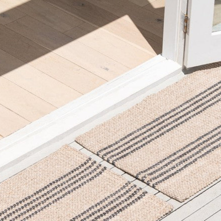 Low-profile Zebra Home Macintosh absorbent front door mat placed seamlessly at a sliding door threshold.