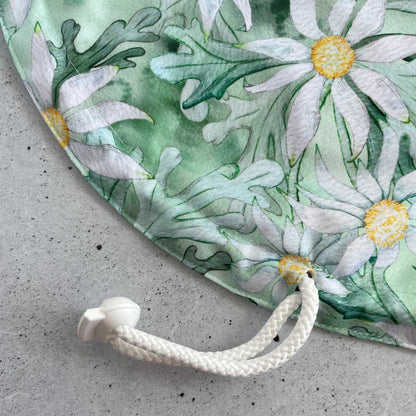 Detail view of the adjustable elastic drawstring and secure plastic toggle mechanism on Produce Pod flannel flower.