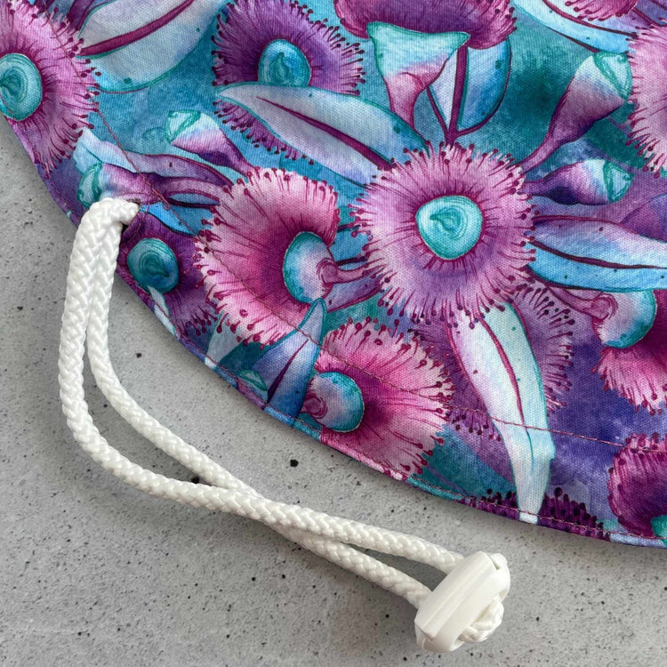Detail view of the adjustable elastic drawstring and secure plastic toggle mechanism on Produce Pod in gum blossom.