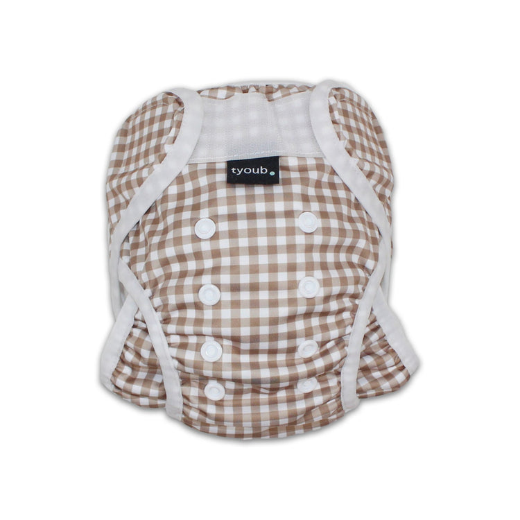 Close-up of an adjustable reusable baby swim nappy with snap buttons in a fawn gingham check pattern.