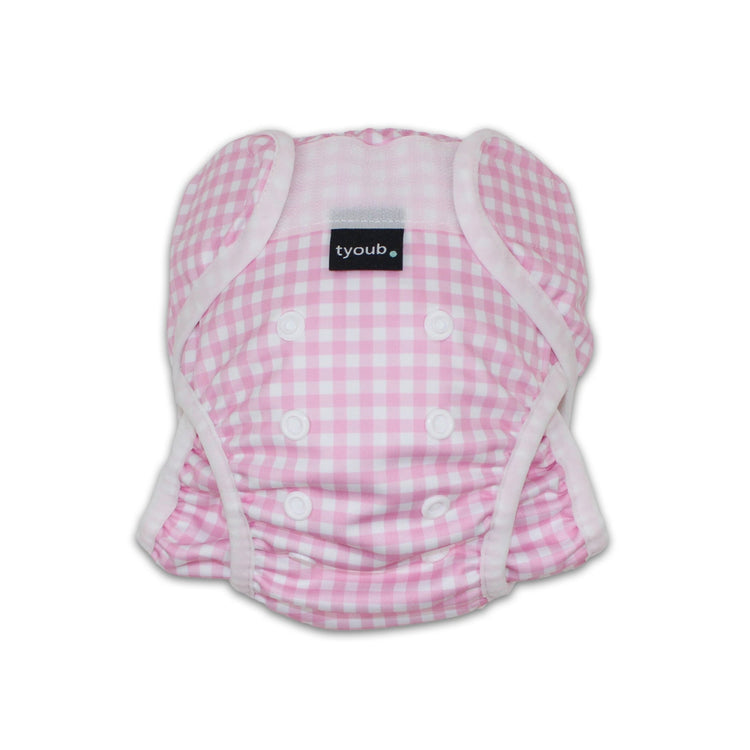 Close-up of an adjustable reusable baby swim nappy with snap buttons in a pink gingham check pattern.