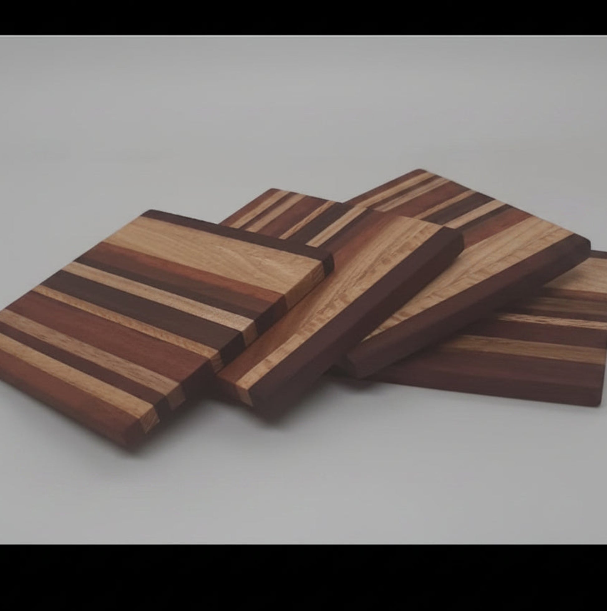 A matching set of four handmade square recycled timber drink coasters stacked neatly together, handcrafted in Australia.