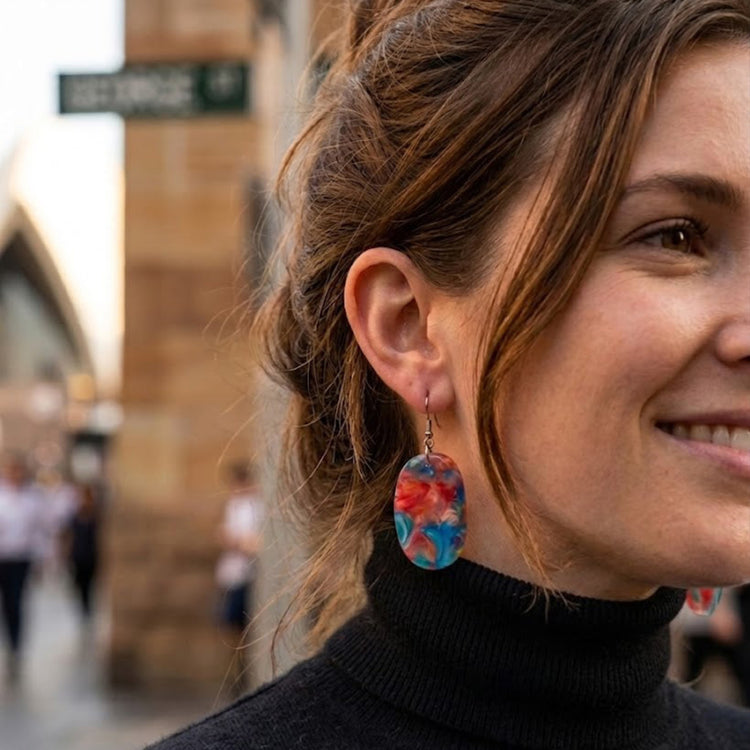 On-model style photo showcasing the fit, drop length, and scale of the upcycled blue and orange geometric oval dangle earrings.