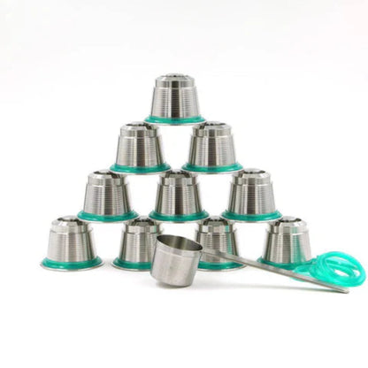 en eco-friendly stainless steel refillable coffee pods arranged with a stainless steel measuring spoon and espresso tamper tool on a white background.
